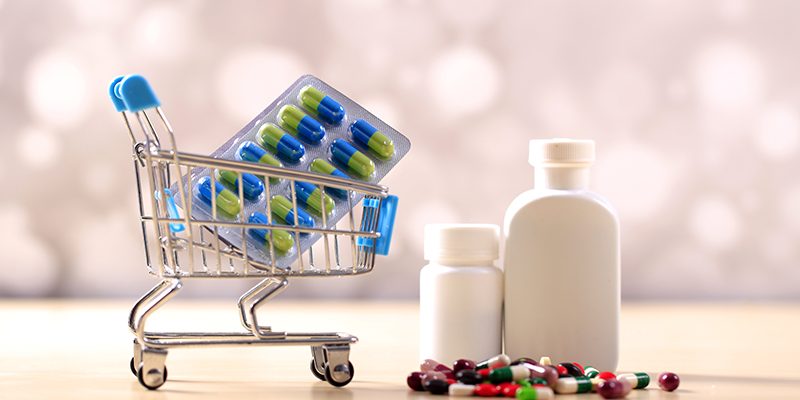 Buy and shopping medicine concept. Various capsules, tablets and medicine in shop trolley. Creative idea for health care, health insurance and pharmaceutical company.